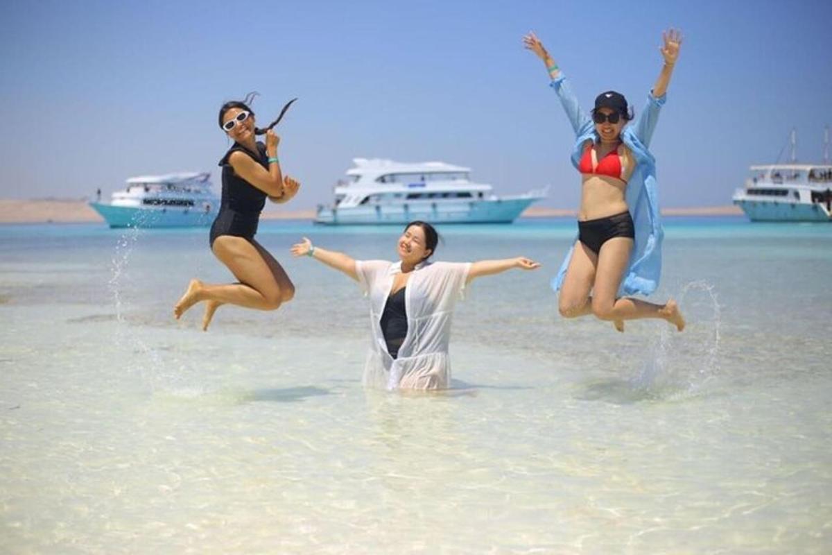 drie vrouwen springen in het water op het strand