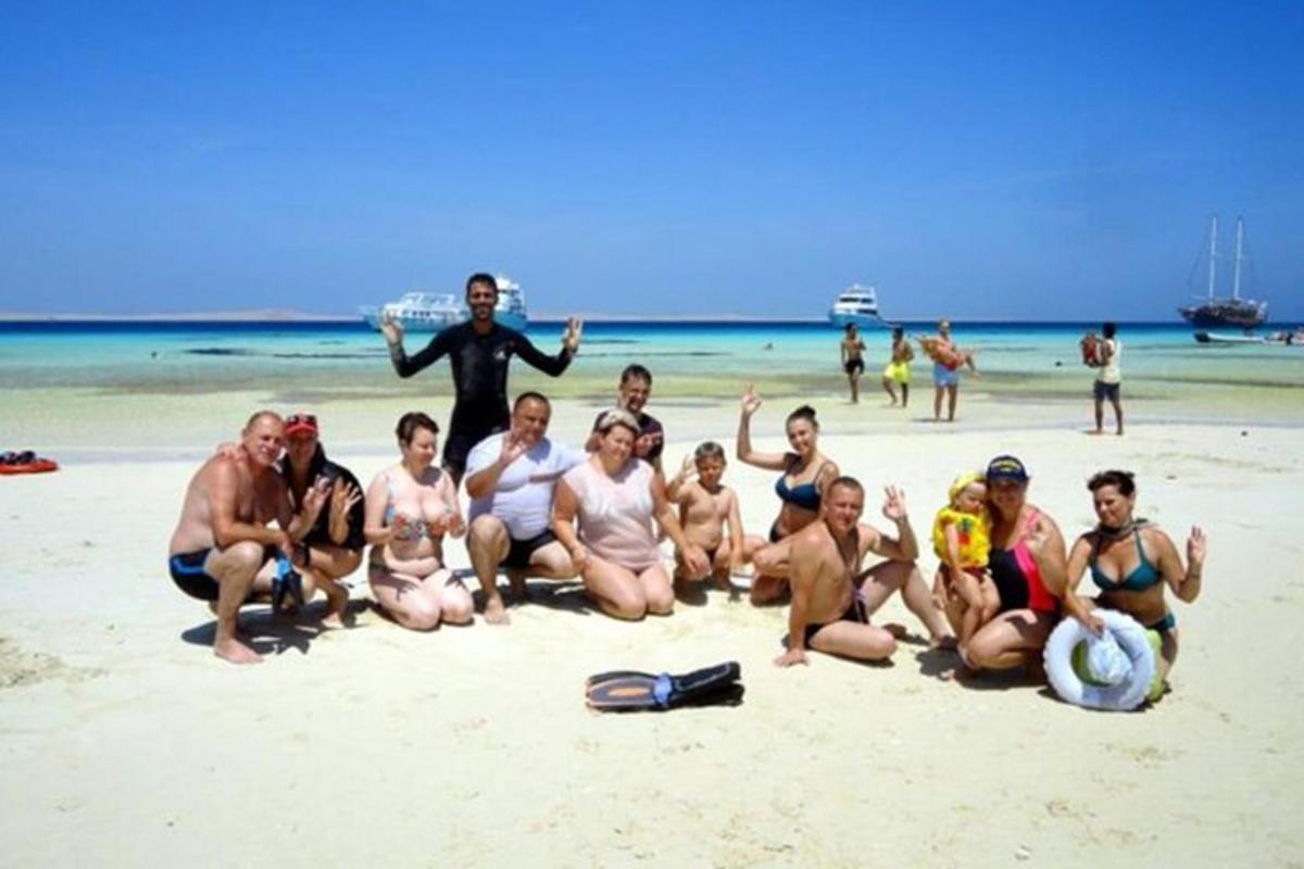 cilvēku grupa pozē fotogrāfijai pludmalē