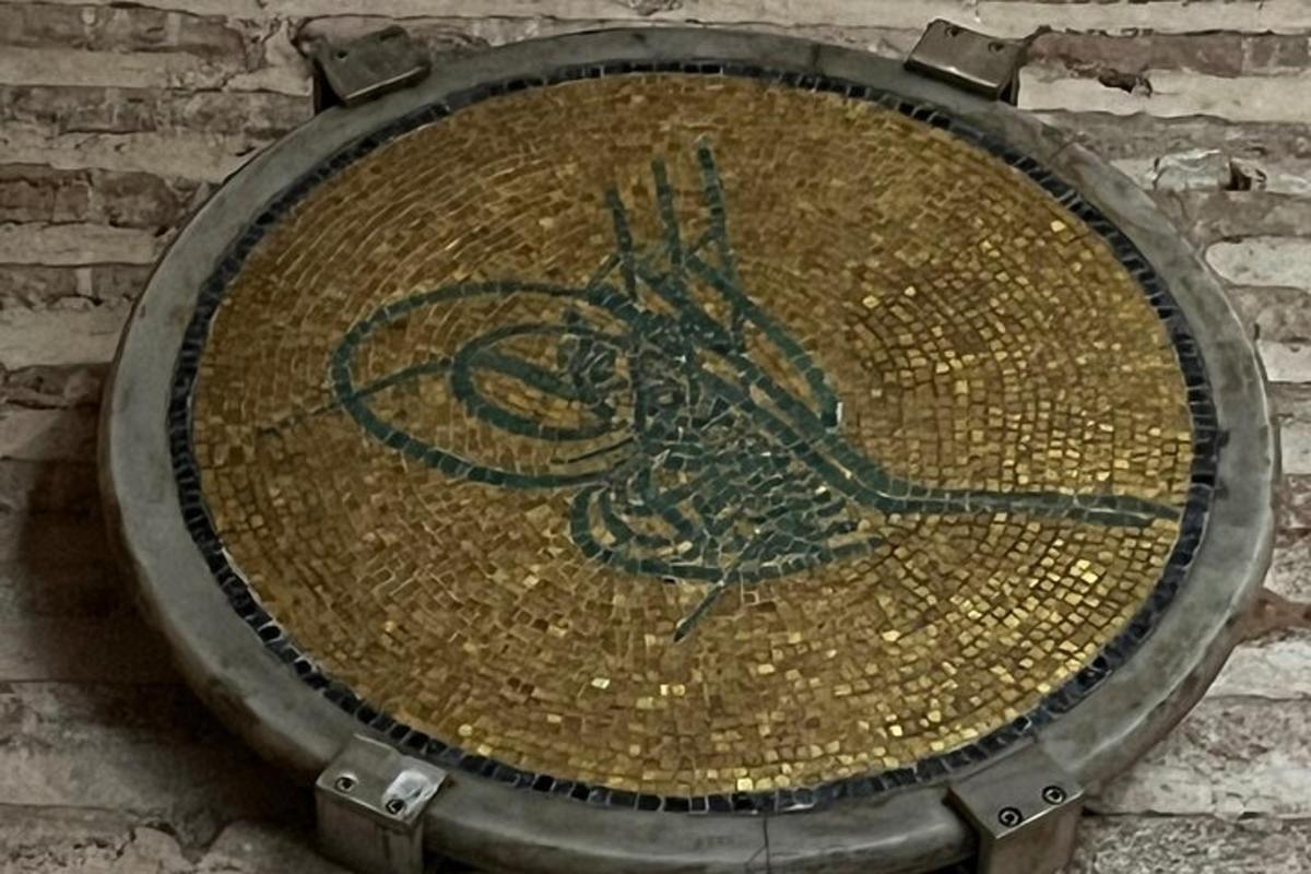 レンガの壁に鳥が描かれた金属板
