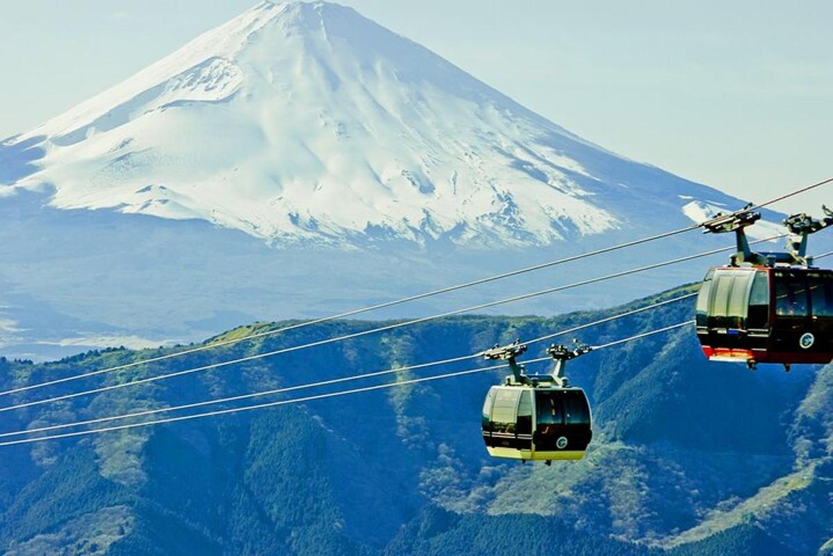 two cable cars flying in front of a mountain