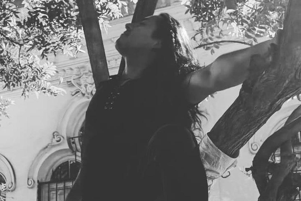 seorang wanita berdiri di sebelah pokok