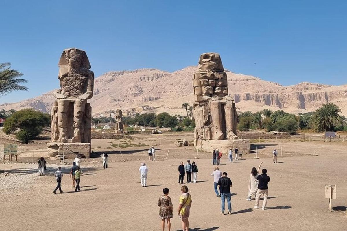 a group of people standing in front of two statues