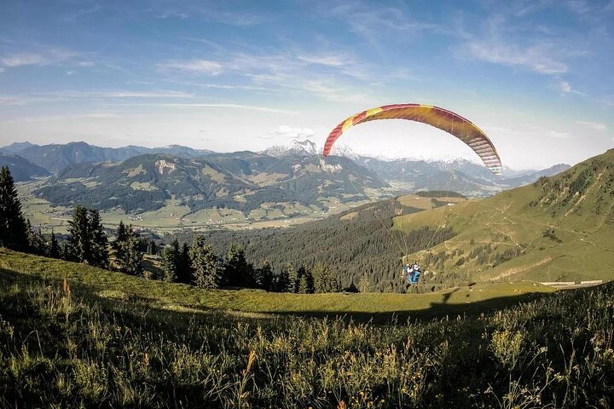 Ein Gleitschirm fliegt in der Luft über einem Berg