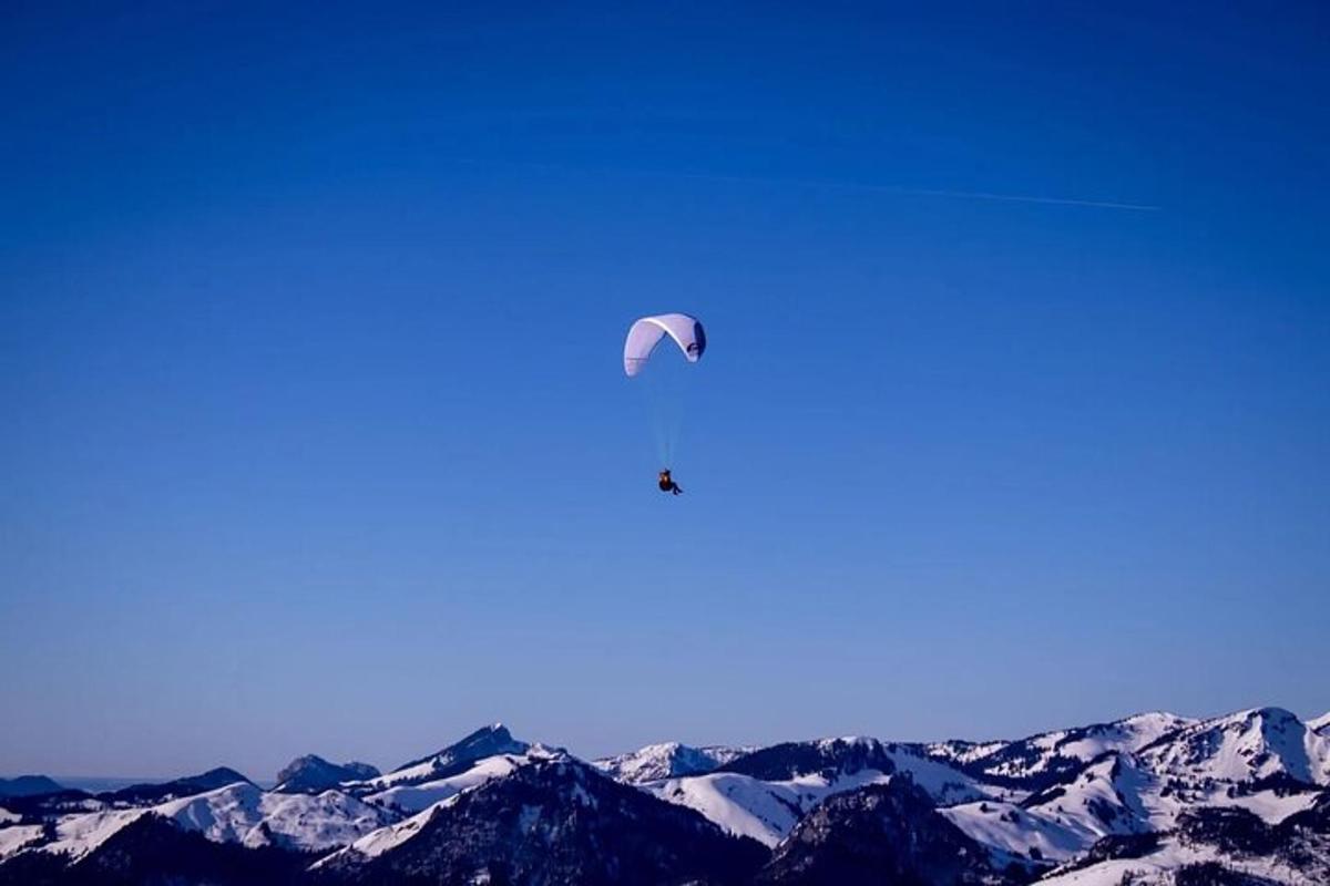 a kite flying in the sky over snowy mountains