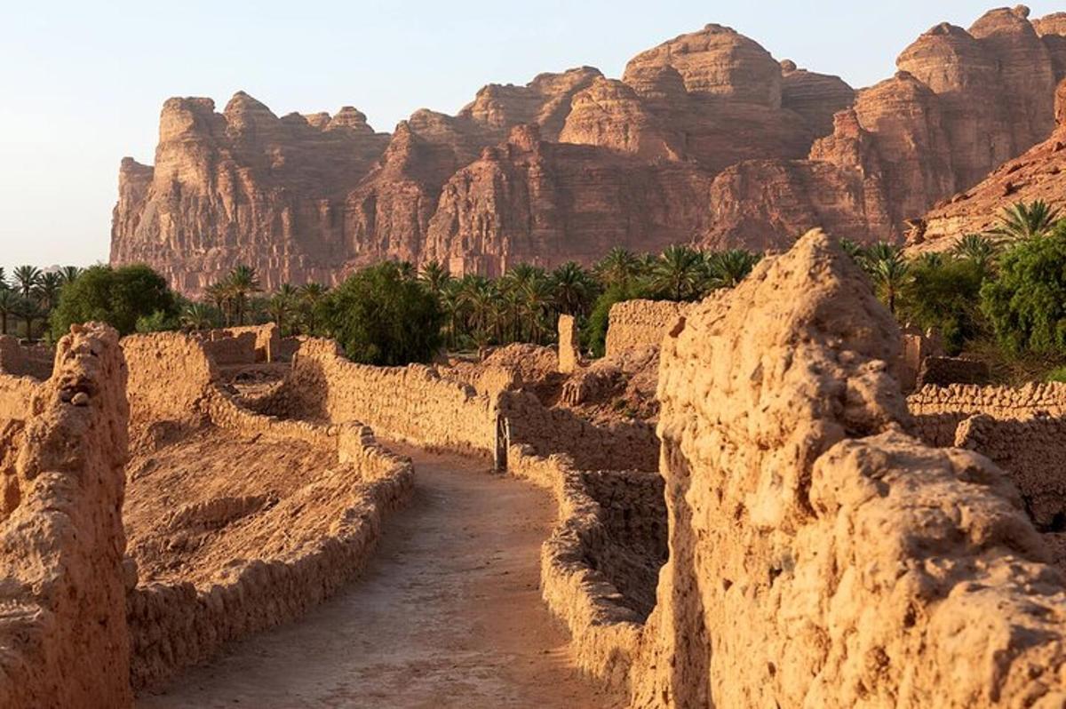 a dirt road in the desert with mountains in the background