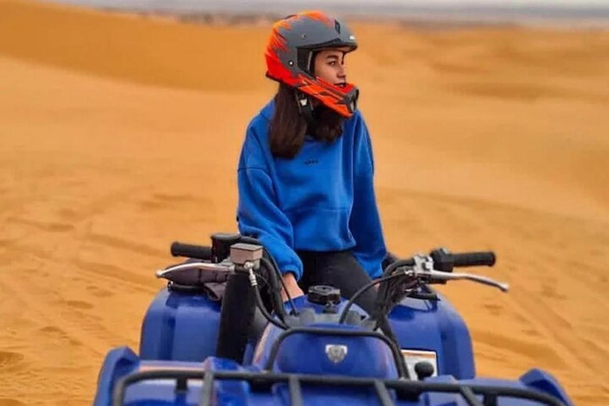 uma mulher andando de moto no deserto