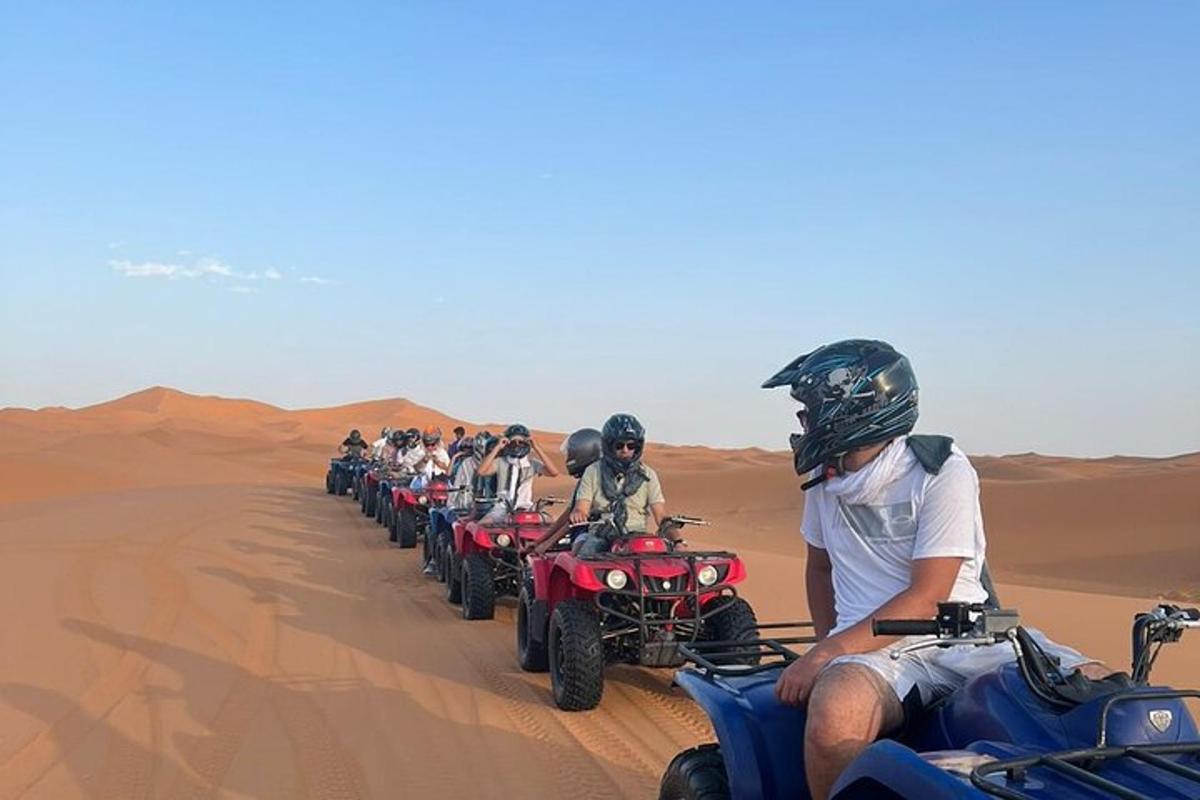 um grupo de pessoas andando de quadriciclo no deserto