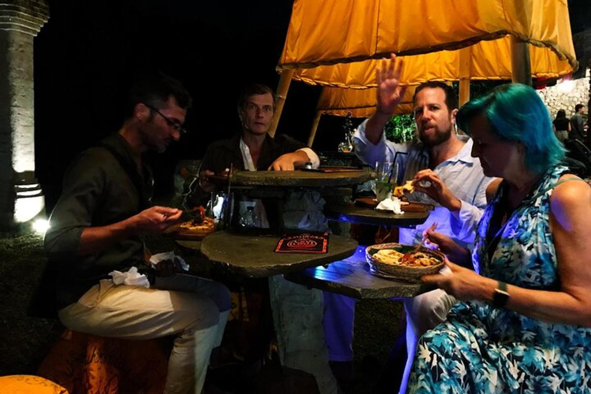 a group of people sitting around a table eating pizza