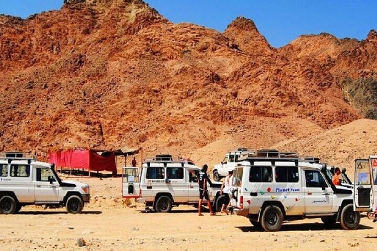 un gruppo di tre veicoli parcheggiati di fronte a una montagna
