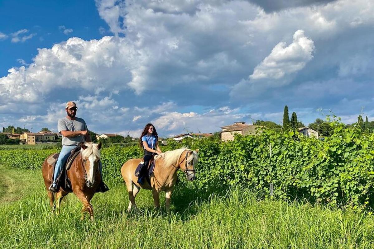 un homme et une femme à cheval dans un champ