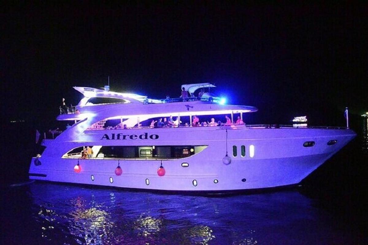 a large white yacht in the water at night