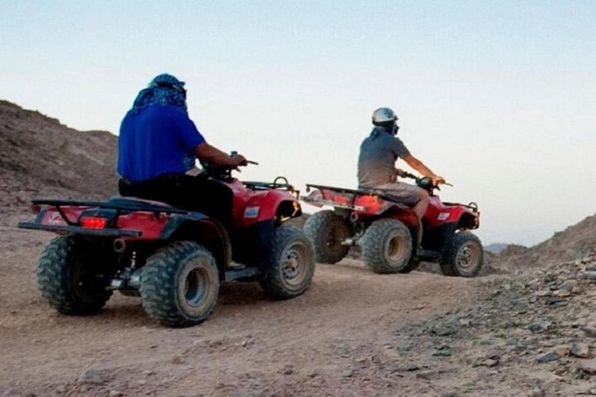 kaks inimest sõidavad ATV-dega kruusateel