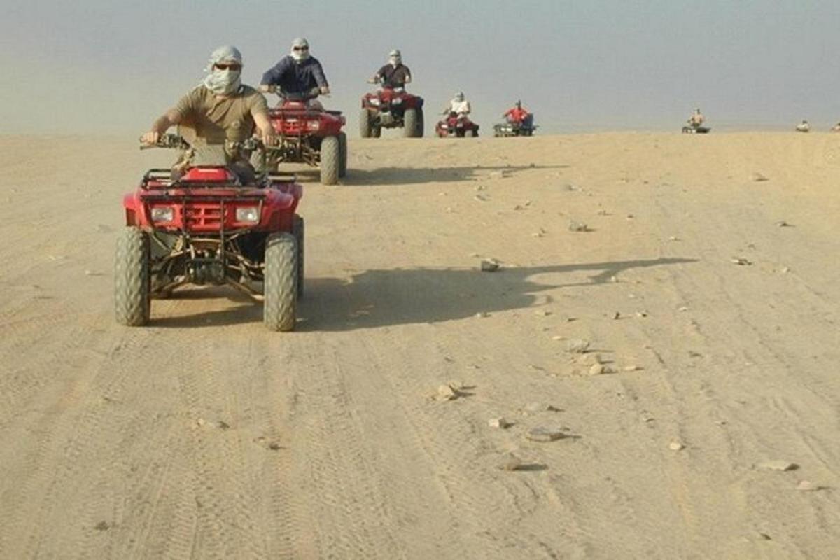 un gruppo di persone in sella a quad nel deserto