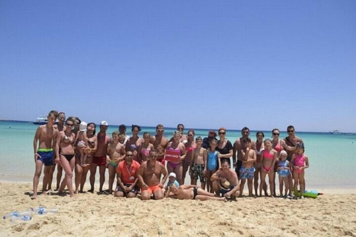 skupina ljudi, ki pozirajo za sliko na plaži