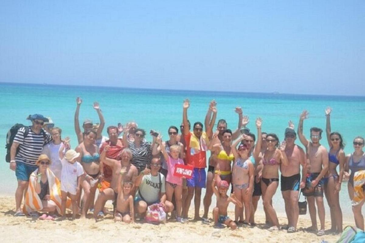 skupina ljudi, ki pozirajo za sliko na plaži