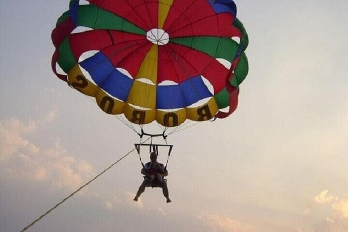 a person riding a parachute in the sky