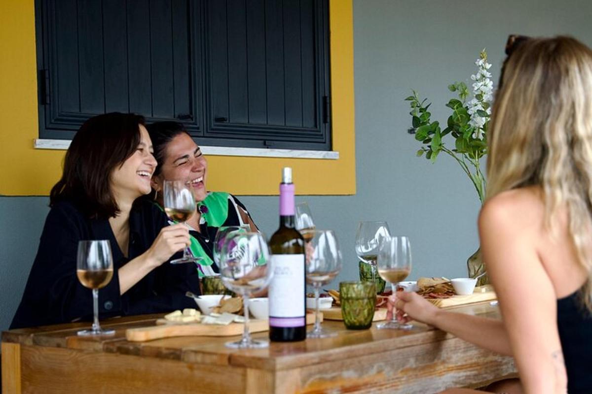 Dos mujeres sentadas en una mesa con copas de vino