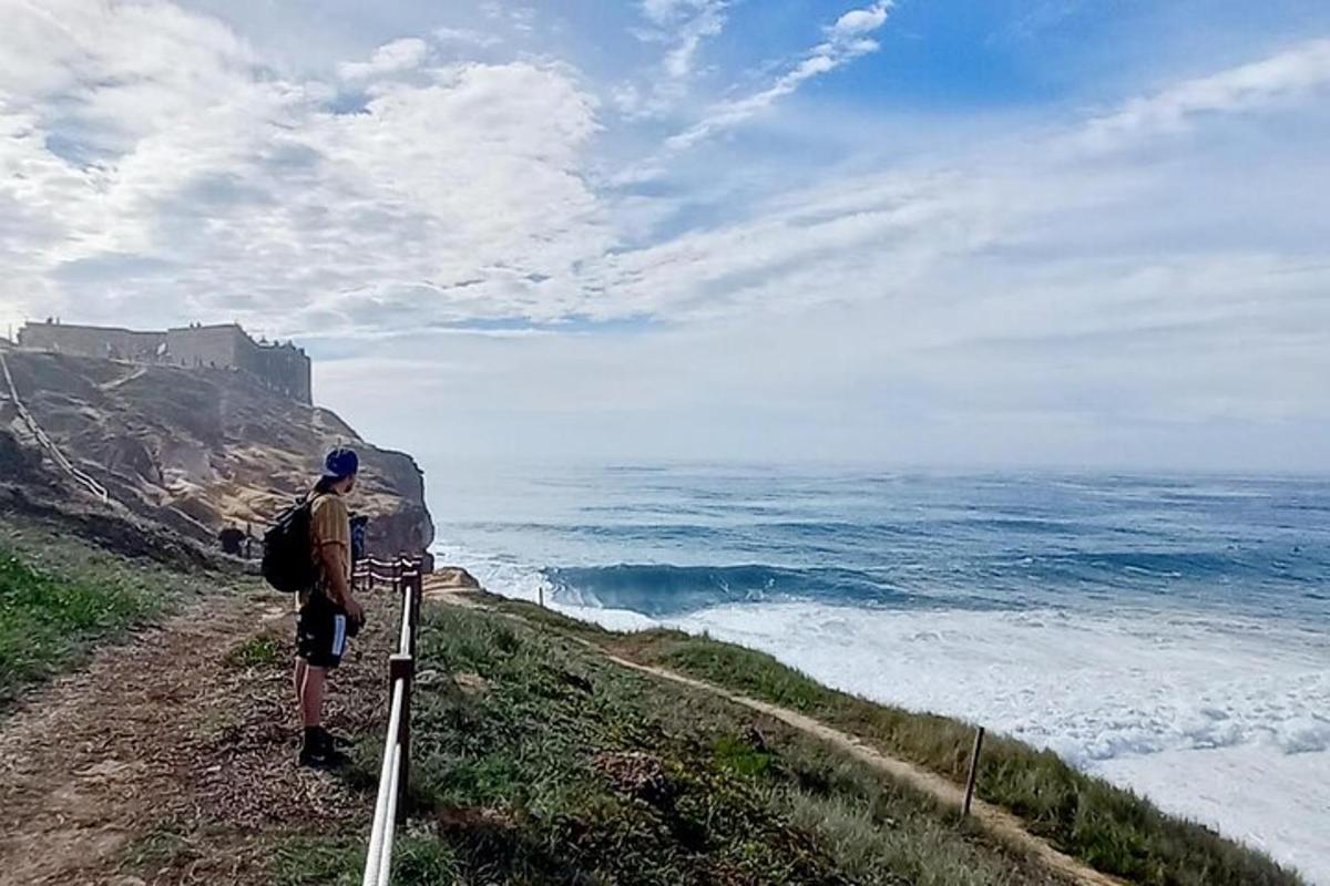 en mand stående på en klippe og kigger på havet