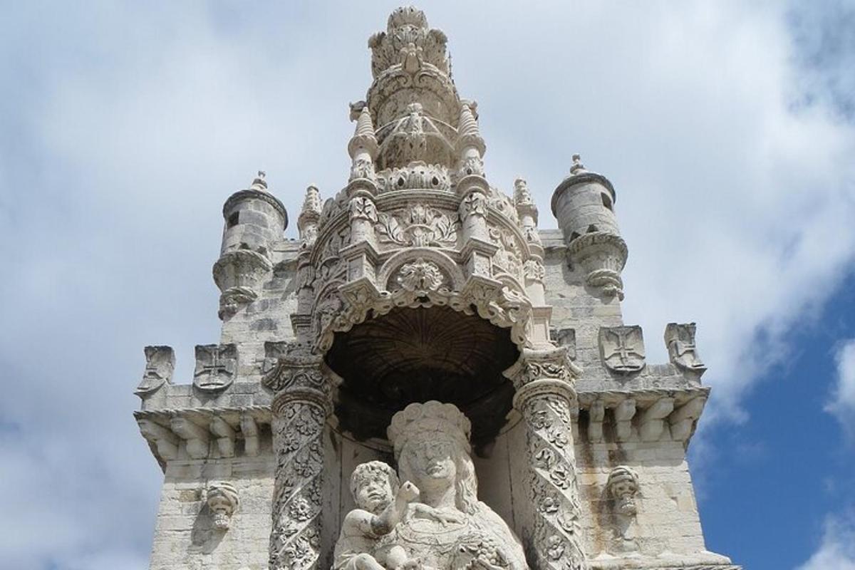 a stone tower with a statue in front of it
