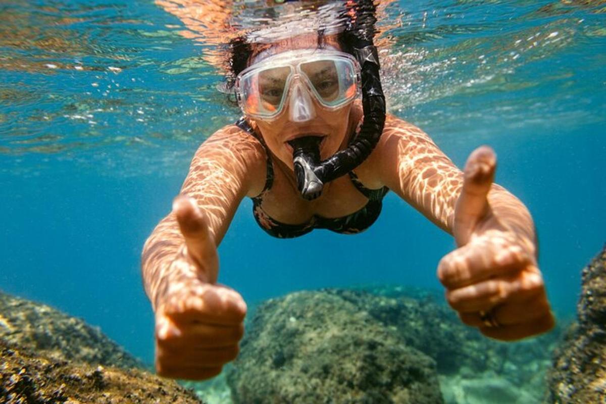 una persona con una maschera da sub che fa un gesto di pollice in su in acqua