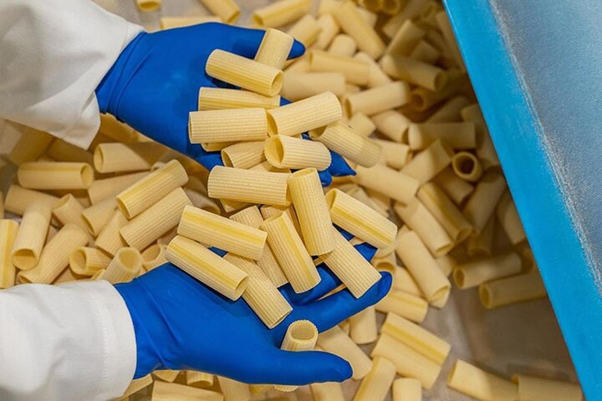 siniste kinnastega inimene hoiab käes pastakandikut