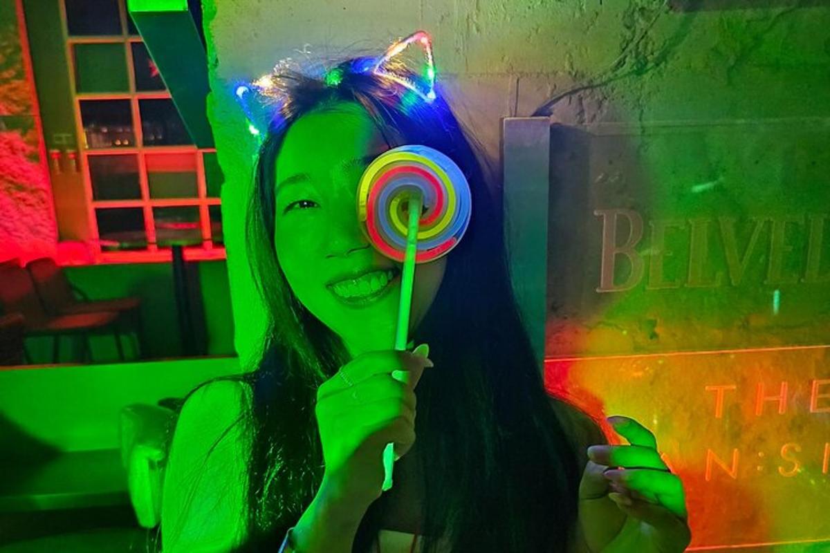 uma garota segurando um pirulito em uma luz verde