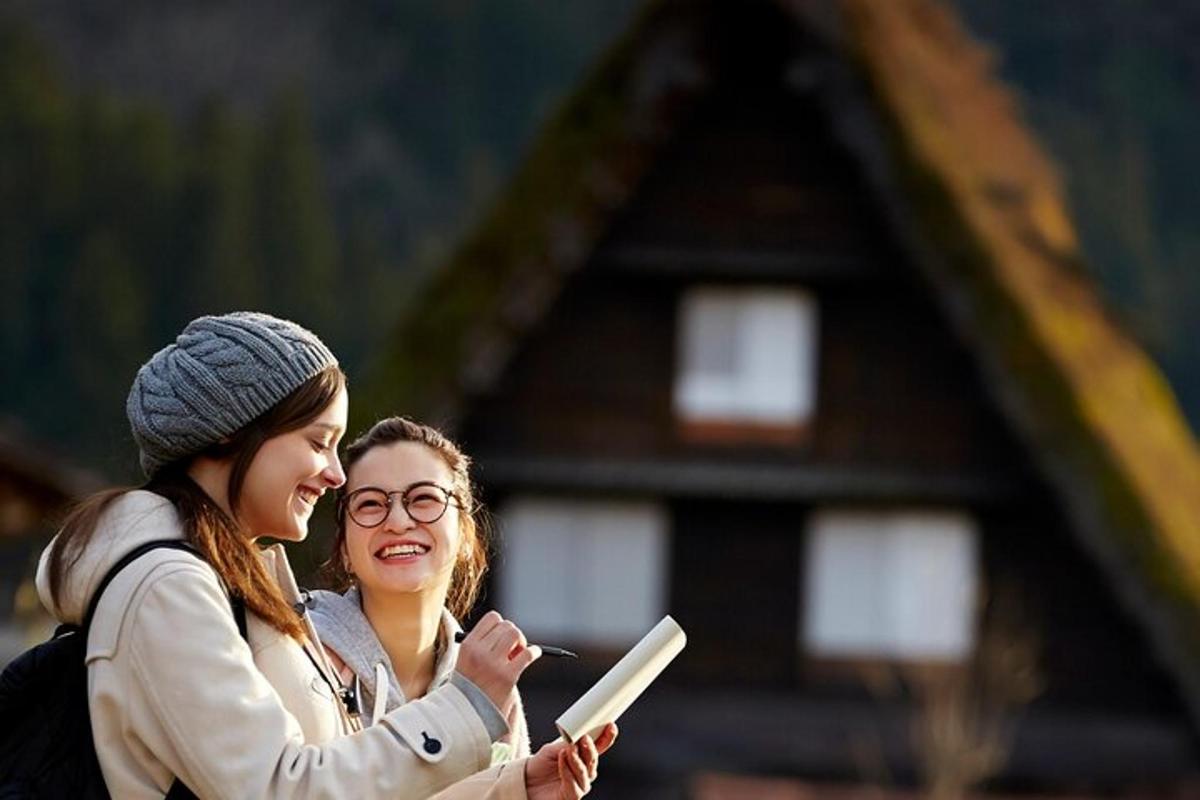 dvě ženy stojící vedle sebe a dívající se na mobilní telefon