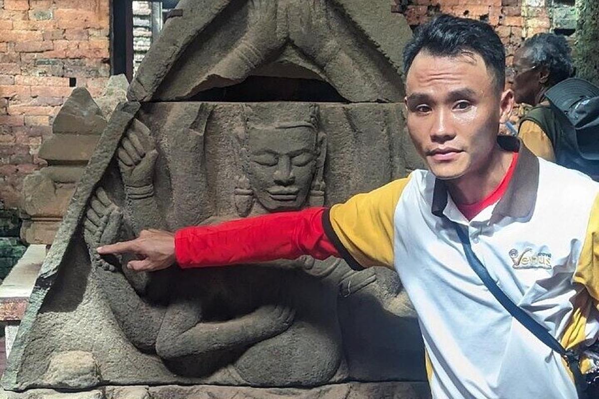 un uomo che indica la statua di un orso