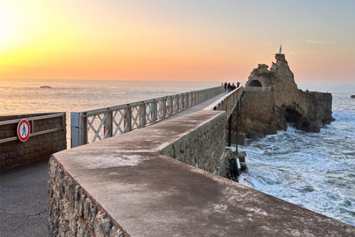 a bridge over the ocean with people standing on it