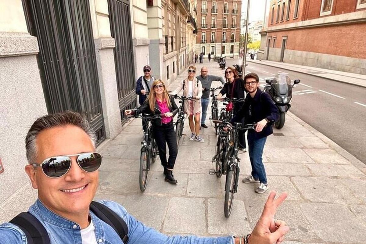 un gruppo di persone in bicicletta lungo un marciapiede