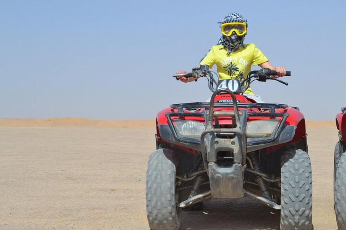 Un hombre en un vehículo de cuatro ruedas en el desierto