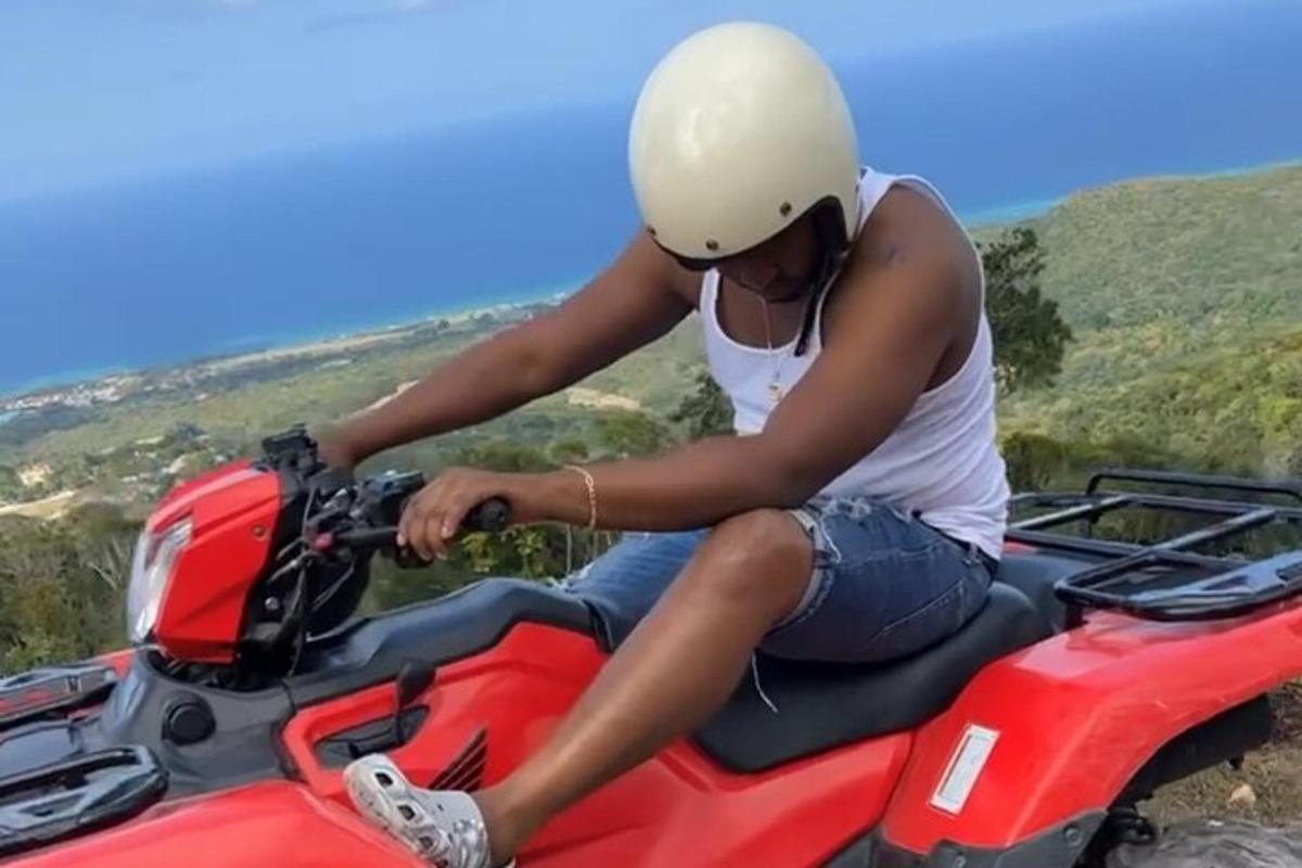 seorang wanita duduk di atas motosikal merah