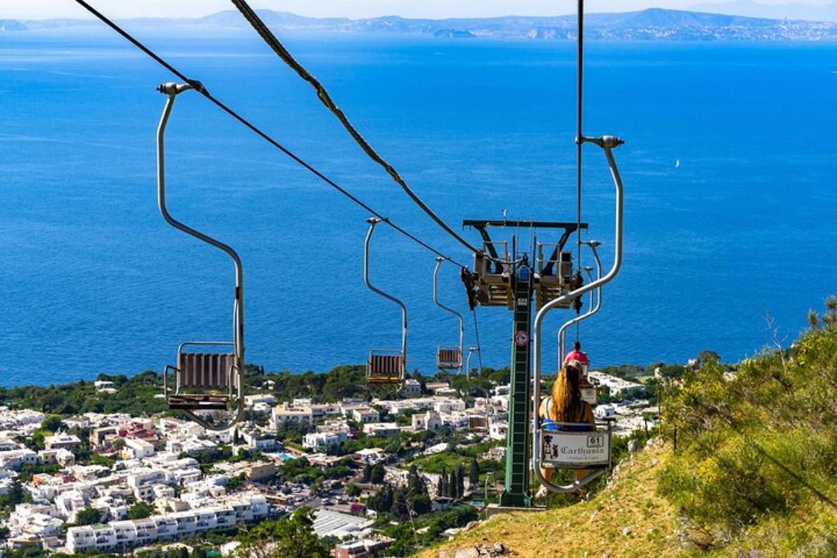 osoba jedoucí na lyžařském vleku nad městem