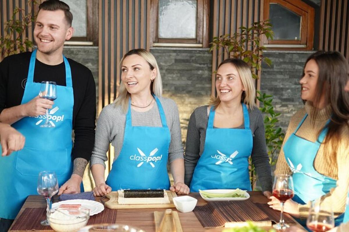 skupina lidí v zástěrách stojících kolem stolu