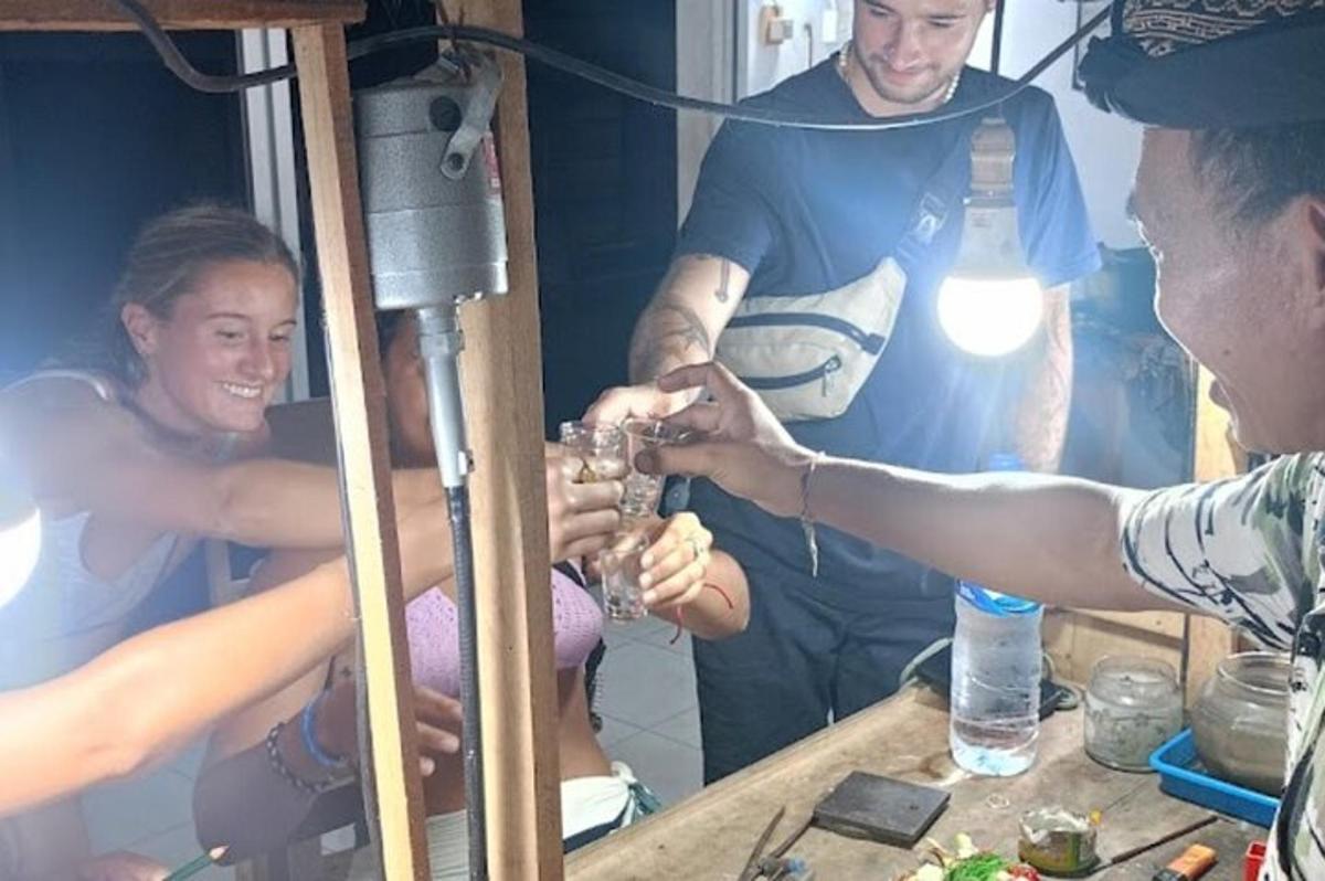skupina lidí sedících kolem stolu a popíjejících víno