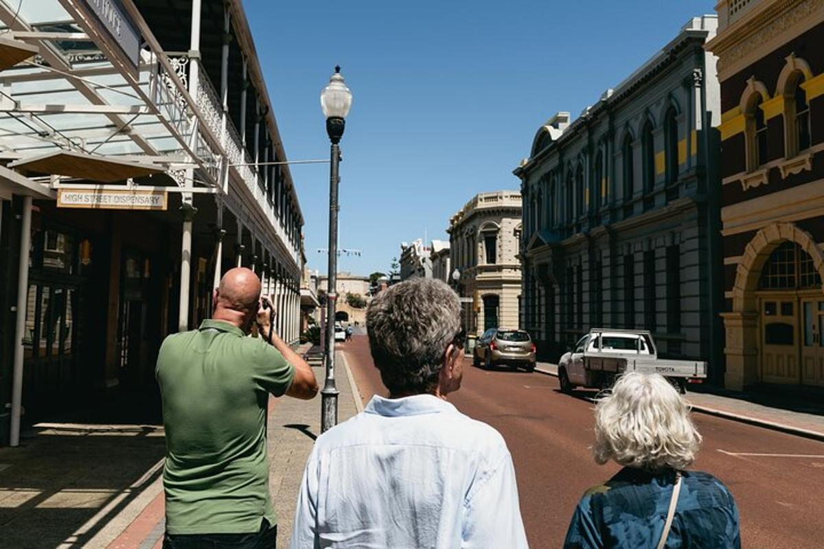 um homem tirando uma foto de pessoas em uma rua da cidade