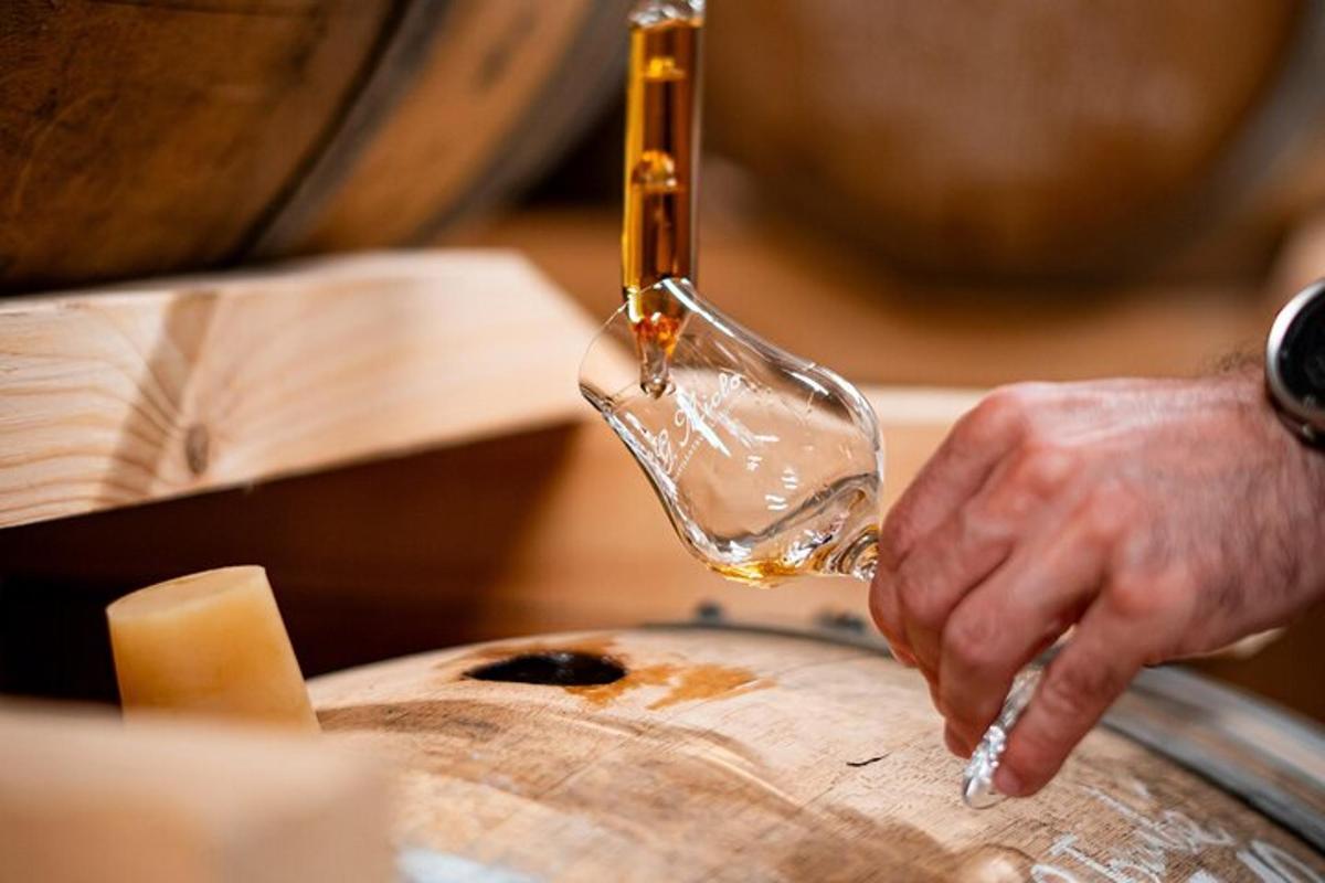 una persona che versa il vino in un bicchiere da vino