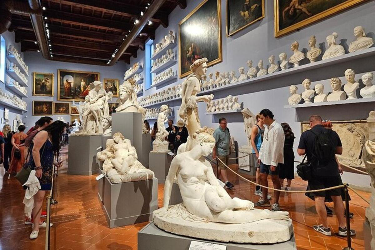 a group of people looking at sculptures in a museum