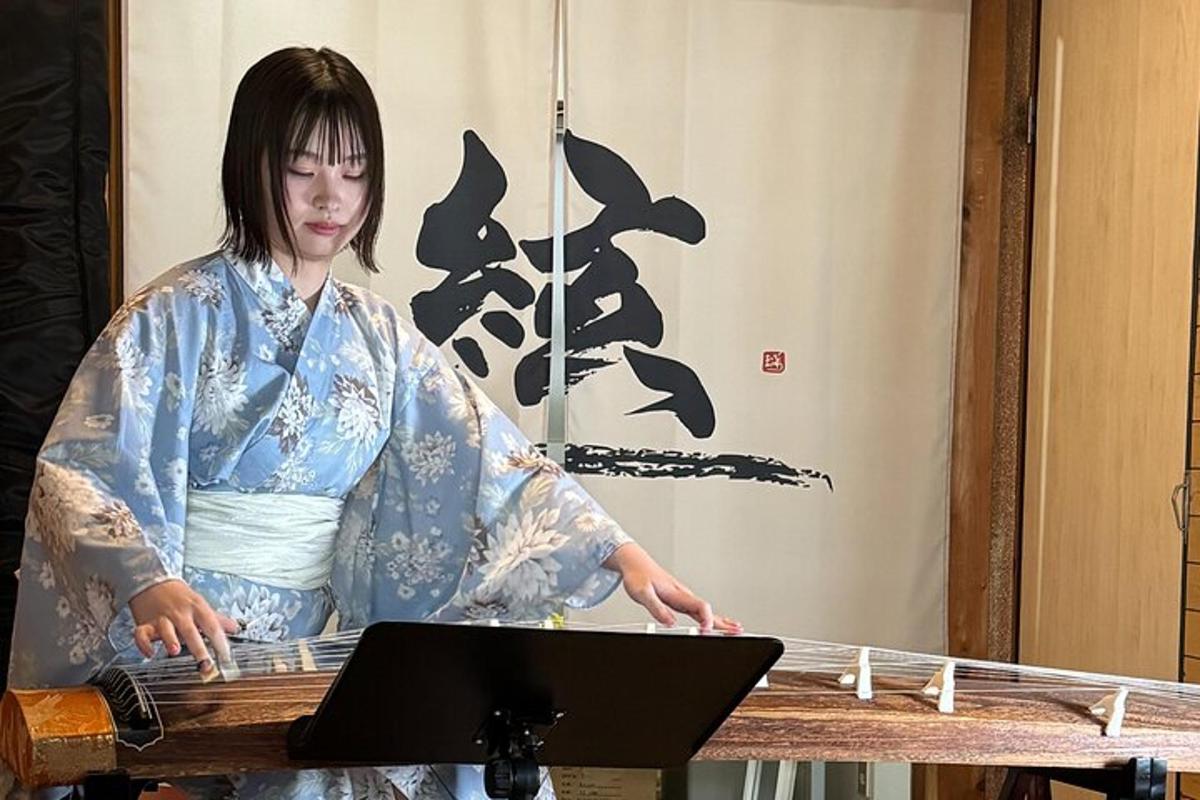 Kona í kimono stendur við borð með fartölvu