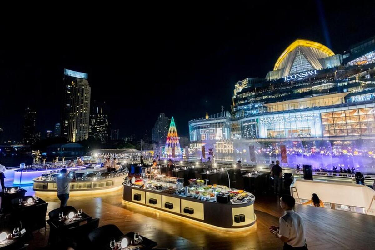 a city lit up at night with people sitting around tables