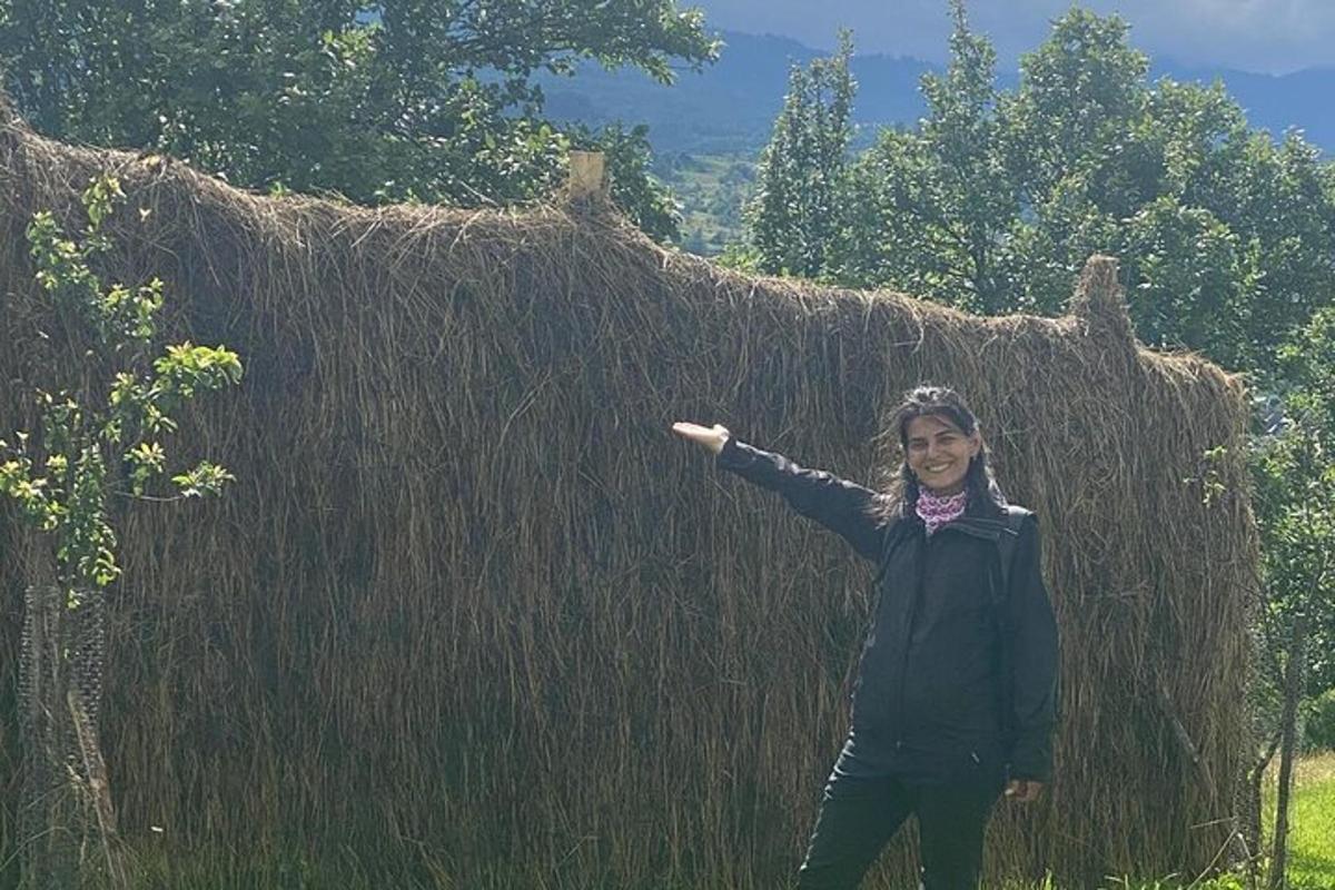 a young girl standing in front of a hay building
