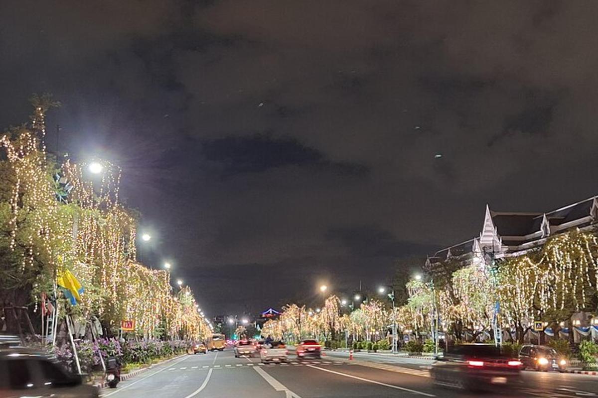 yoldaki arabaların ve Noel ışıklarının olduğu bir şehir caddesi