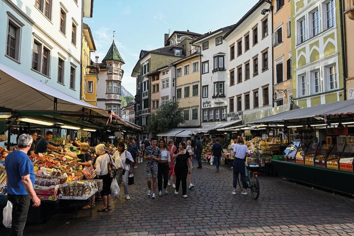 Skupina lidí procházejících se trhem s ovocem a zeleninou