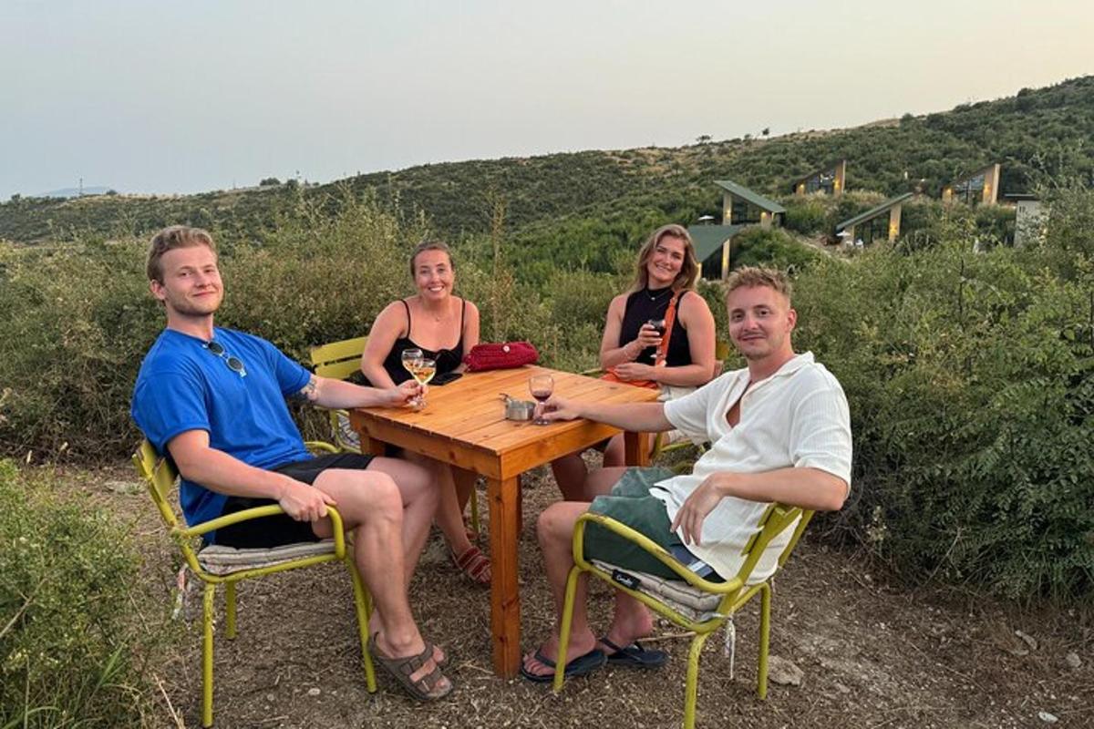 un grup de persones assegudes al voltant d'una taula de fusta