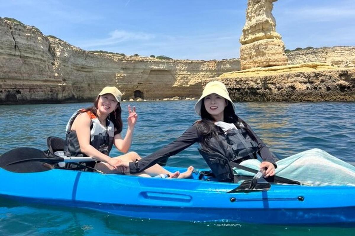 two women sitting in a blue kayak in the water