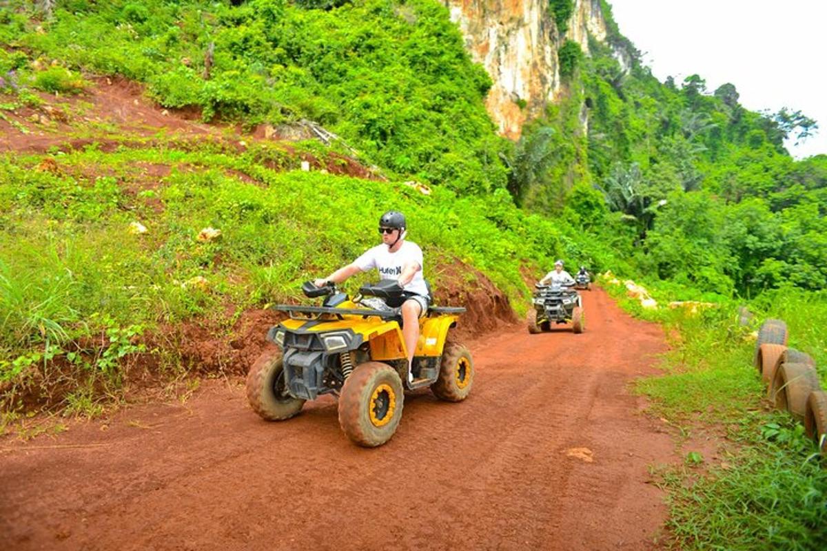 two people riding on atvs on a dirt road