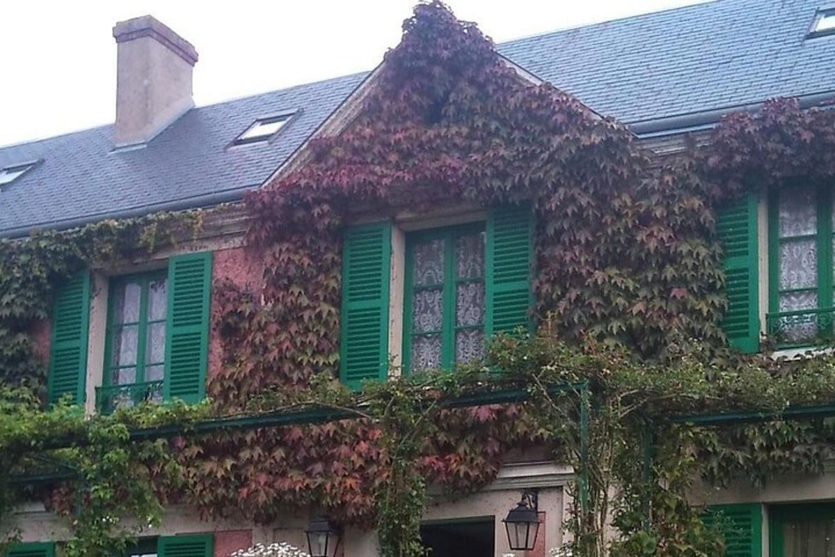 a house covered in ivy with green shutters