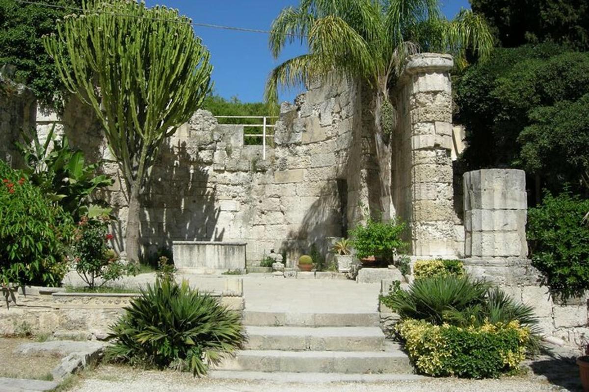 un edifici de pedra amb escales i palmeres