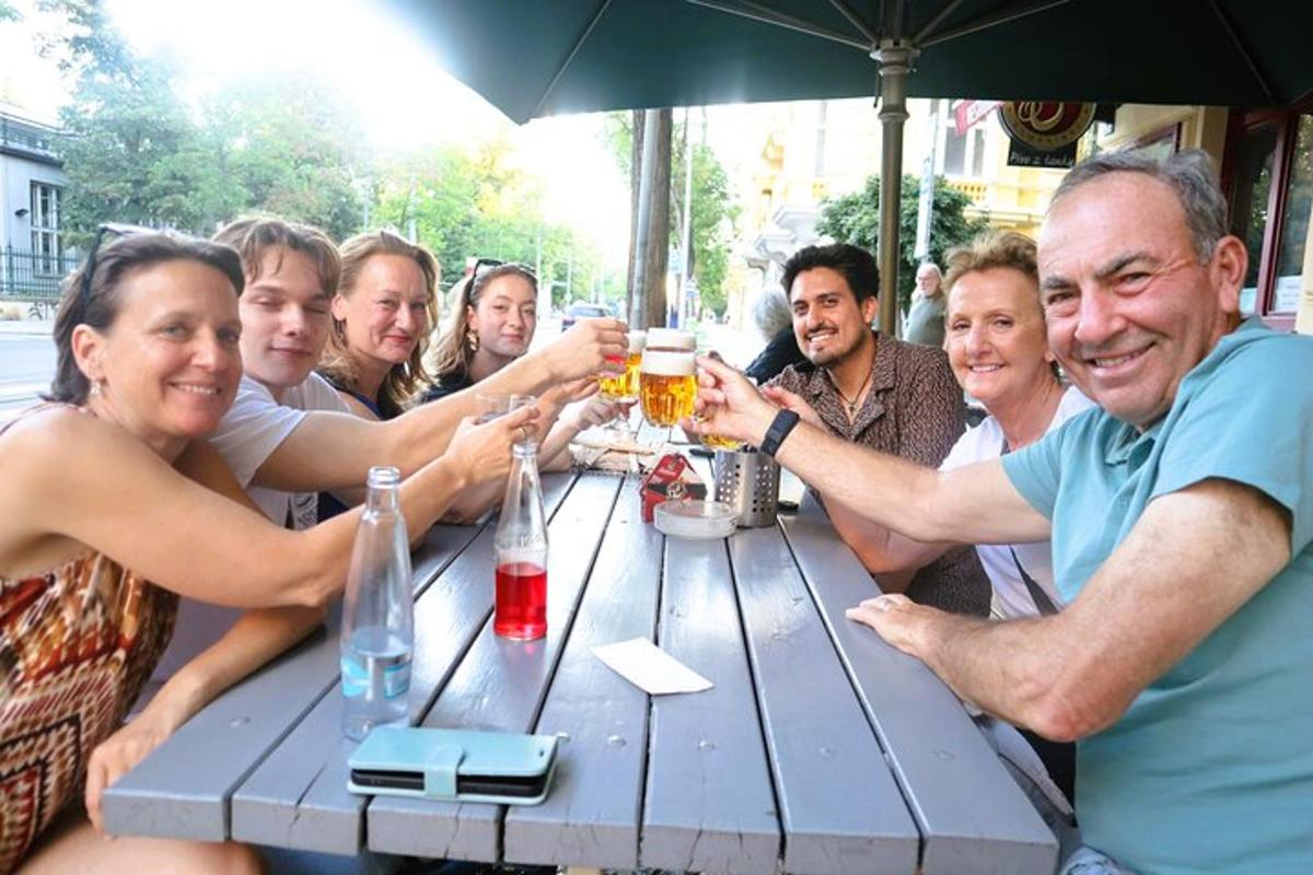een groep mensen die rond een tafel zitten met drankjes
