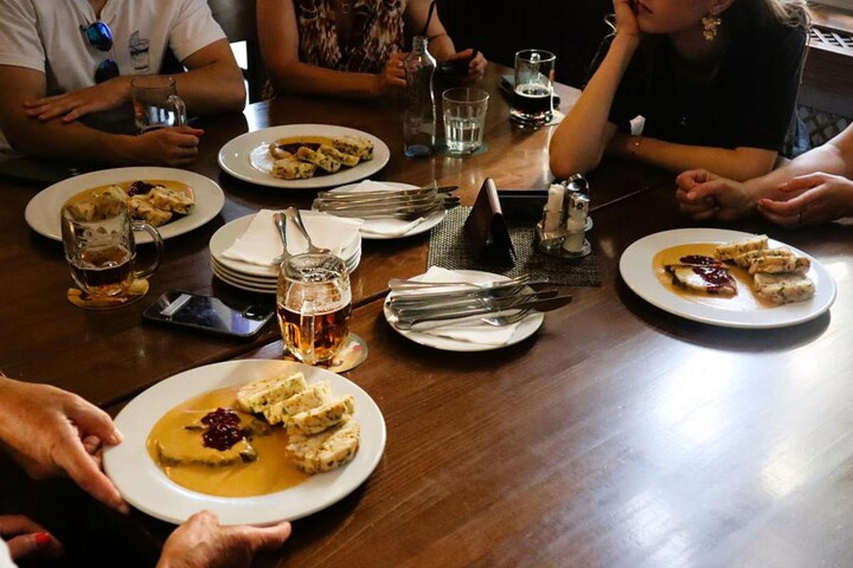 en grupp människor som sitter runt ett bord med tallrikar med mat